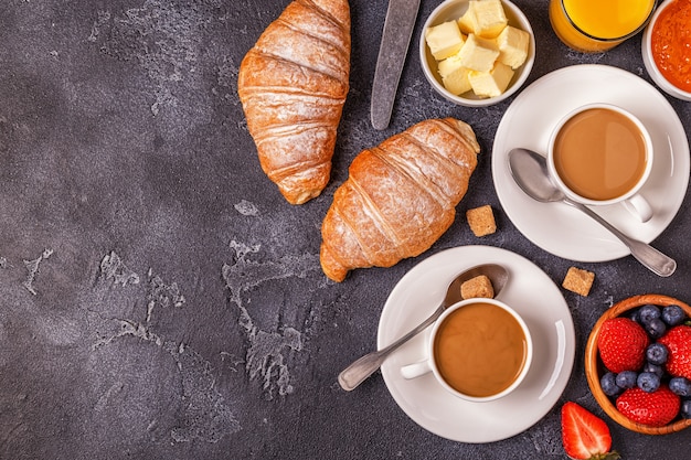 Colazione con croissant freschi, succo d'arancia e caffè