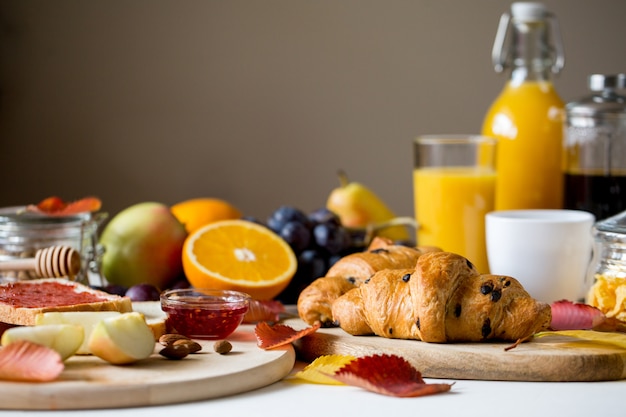 Colazione con croissant Succo d&#39;arancia in una bottiglia di vetro.