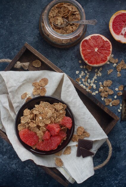 Colazione con fiocchi d'avena biologici e pompelmo su tavola di pietra scura