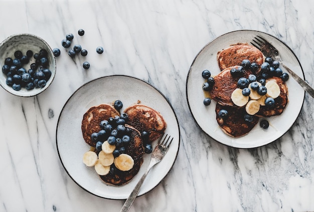 Colazione con frittelle di banana con mirtillo e miele nei piatti