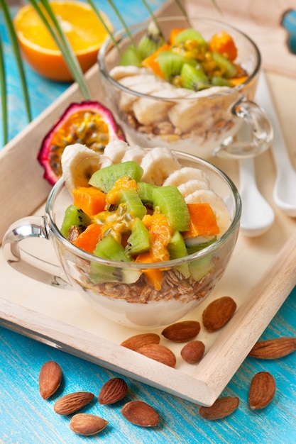 Colazione con muesli, yogurt, frutti tropicali