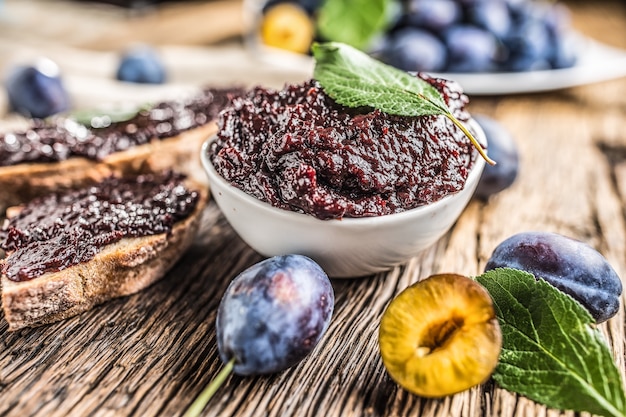 Colazione con pane fatto in casa con marmellata di prugne e prugne mature fresche.