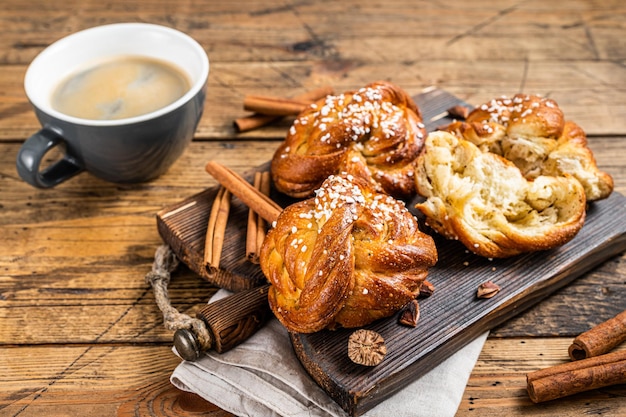 Colazione con panini o panini alla cannella, Kanelbullar svedese. fondo in legno. Vista dall'alto.