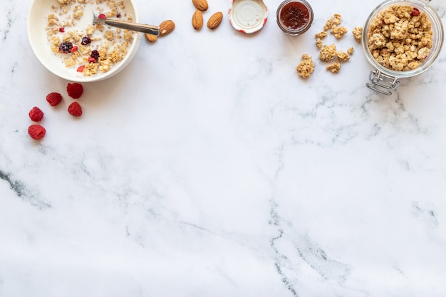 Colazione con scricchiolio di frutti rossi, latte di mandorle e marmellata su marmo