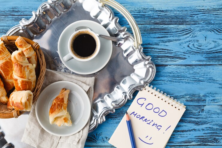 Colazione con tè e cornetto, note buongiorno sul tavolo