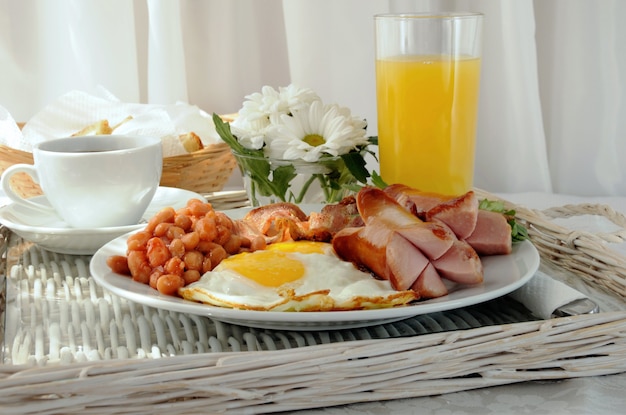 Colazione con uova strapazzate, bacon, salsiccia e fagioli