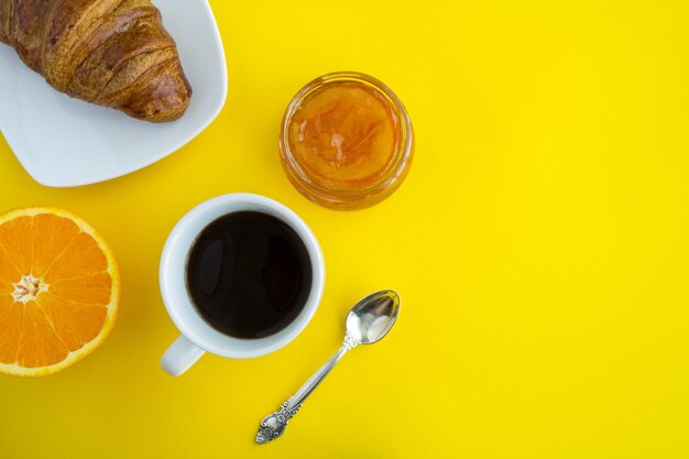 Colazione continentale con caffè, marmellata di arance e croissant. Vista dall'alto.