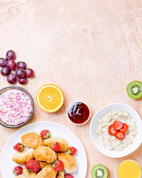 Colazione continentale con cereali uova fritte croissant frutta e bevande su tavolo tessuto spazio di copia tavolo con vari spuntini e cibi sani su sfondo rustico