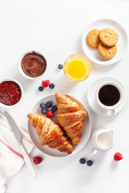 Colazione continentale con cornetto, marmellata, crema al cioccolato e caffè. Vista dall'alto