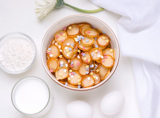 Colazione cucinare minuscole frittelle di cereali esilaranti accanto agli ingredienti.