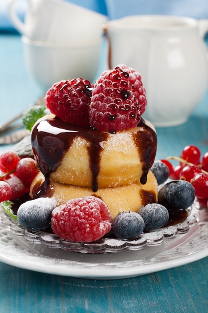 Colazione del mattino con mini ciambelle e frutti di bosco