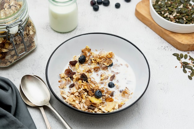 Colazione di avena integrale, muesli con frutta secca e mirtillo, latte e miele.