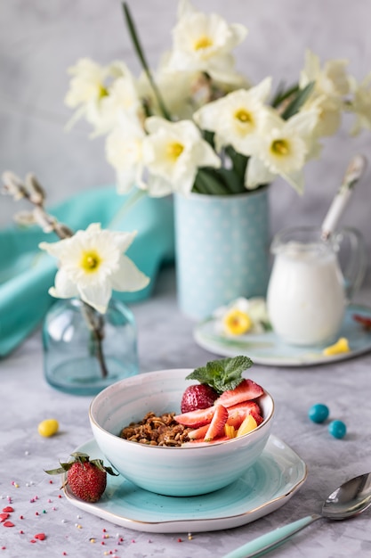 Colazione di primavera con fiori, cheesecakes e frutti di bosco freschi