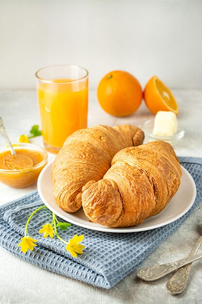 Colazione europea con marmellata di croissant freschi e succo d'arancia Colazione su un tavolo luminoso vista laterale Sfondo alimentare