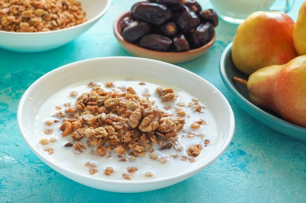 Colazione europea tradizionale. Latte e muesli Muesli, datteri e pere fresche.