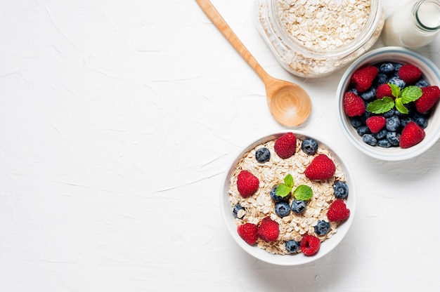 Colazione, farina d&#39;avena con mirtillo e lampone sulla ciotola bianca al mattino.