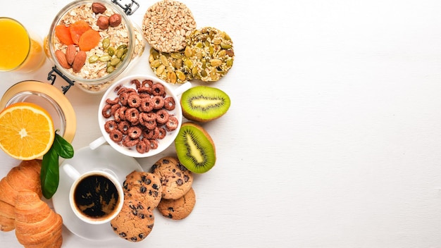 Colazione fitness, muesli, latte, frutta, noci e semi, su una superficie di legno. Vista dall'alto. Spazio libero per il testo.