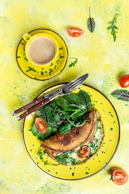 Colazione Frittata con uova formaggio e insalata di spinaci Frittata frittata italiana su un piatto giallo su sfondo giallo Colazione cheto chetogenica immagine verticale posto per testo vista dall'alto