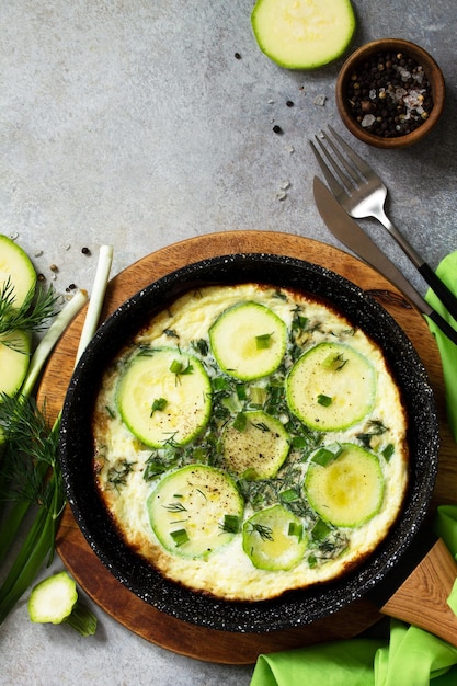 Colazione Frittata estiva con zucchine ed erbe aromatiche su un tavolo di pietra o ardesia Vista dall'alto Copia spazio