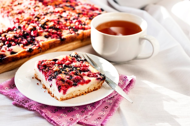 Colazione gustosa Torta deliziosa con frutti di bosco assortiti e ricotta e una tazza di tè Copia spazio