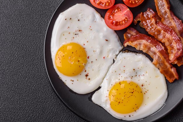 Colazione inglese con uova fritte bacon fagioli pomodori spezie ed erbe