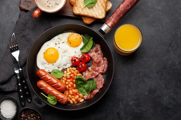 Colazione inglese con uova fritte fagioli bacon e salsicce