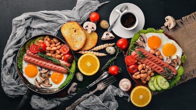 Colazione inglese Uova fritte salsicce pancetta fagioli toast pomodori tazza di caffè su tavolo di pietra Vista dall'alto con spazio per il testo