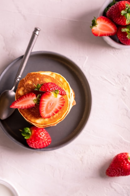 Colazione mattutina con frittelle e fragole