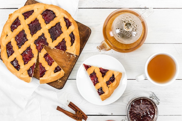 Colazione mattutina Torta con marmellata e tè su fondo di legno