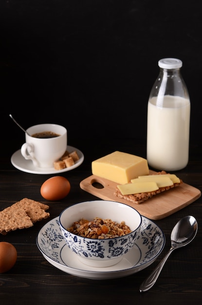 Colazione: muesli con latte, uova, formaggio, pane dietetico, caffè con zucchero di canna