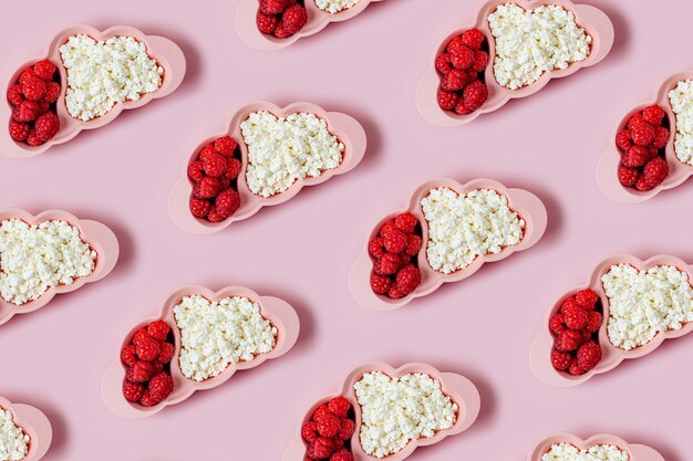 Colazione per bambini. Piatto a forma di nuvola con ricotta e frutti di bosco su sfondo rosa. Idea alimentare per bambini.