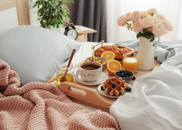 Colazione romantica con croissant al caffè e fiori di rosa