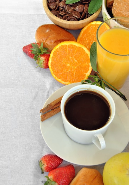 Colazione salutare composta da caffè, succo di frutta, frutta e croissant