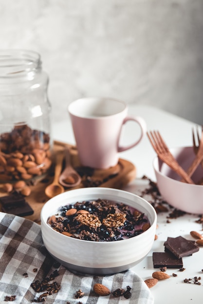 Colazione salutare. Frullato di muesli al cioccolato e una tazza di caffè. Mandorle, frutti di bosco e yogurt in un piatto. Ingredienti. eko, vegano