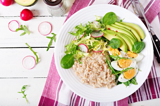 Colazione salutare. Menu dietetico. Porridge di farina d'avena e insalata di avocado e uova.