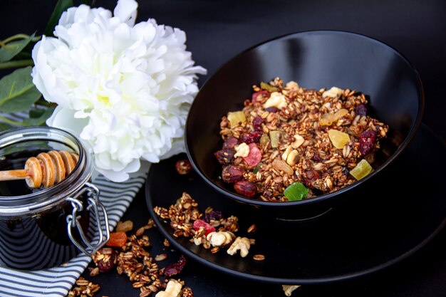 Colazione salutare. Muesli con miele su piastra nera.