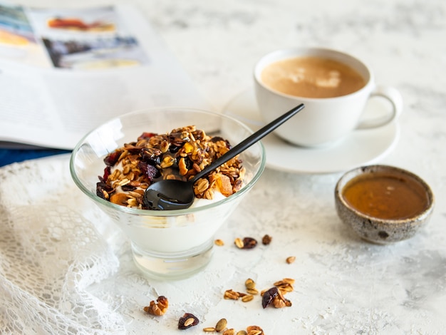 Colazione salutare. Muesli, muesli con semi di zucca, miele, yogurt in una ciotola di vetro