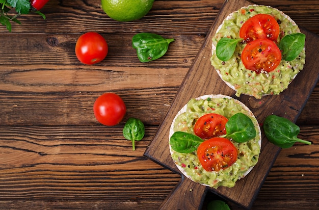 Colazione salutare. Panino con pane croccante con guacamole e pomodori