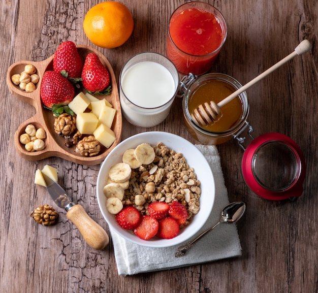 colazione sana con latte, muesli, miele e fragole