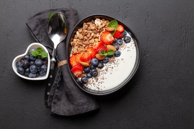 Colazione sana con una ciotola di yogurt muesli e frutti di bosco freschi