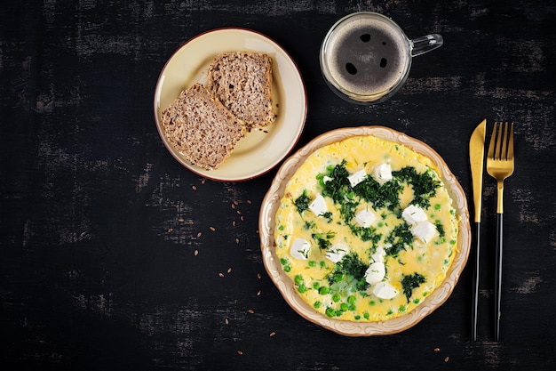 Colazione sana Frittata con piselli feta e aneto Sfondo scuro Vista dall'alto