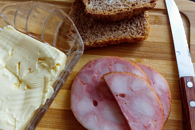 Colazione sana prosciutto pane e burro su un tagliere Cibo sano con prodotti naturali