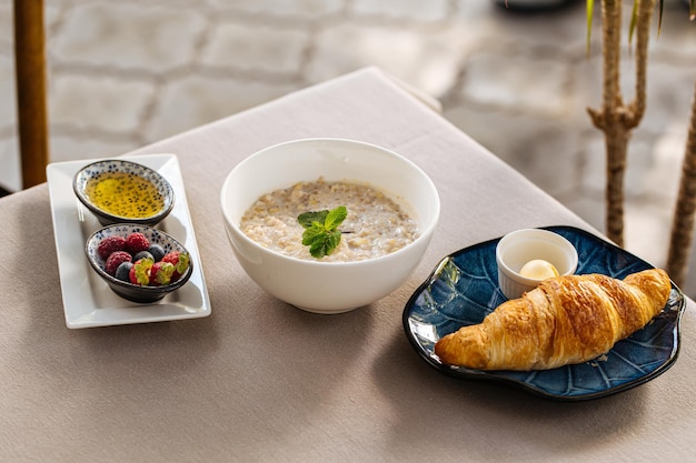 Colazione servita con porridge e croissant