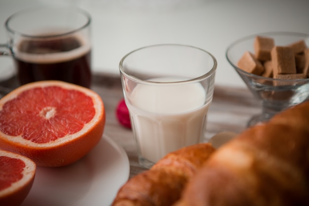 Colazione su un vassoio - caffè, cornetto, succo di frutta fresco