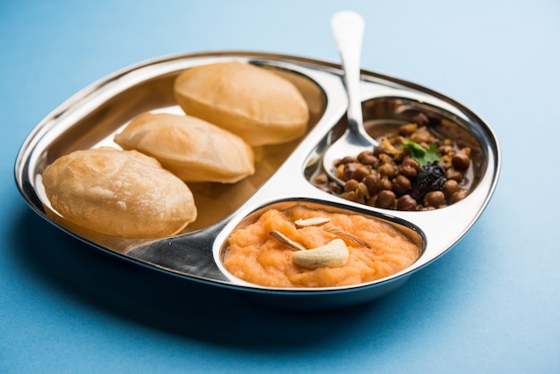 Colazione Suji o Sooji Halwa Puri o Sheera o Shira Poori, servita in un piatto e una ciotola. messa a fuoco selettiva