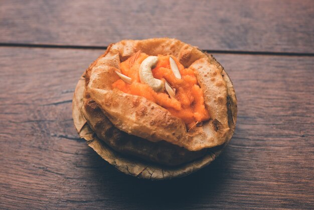 Colazione Suji o Sooji Halwa Puri o Shira Poori, servita in un piatto e una ciotola. messa a fuoco selettiva