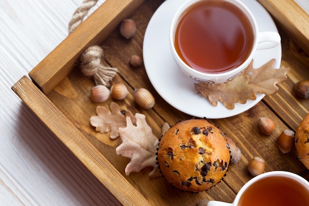 Colazione - torta e tazza di tè su un vassoio di legno