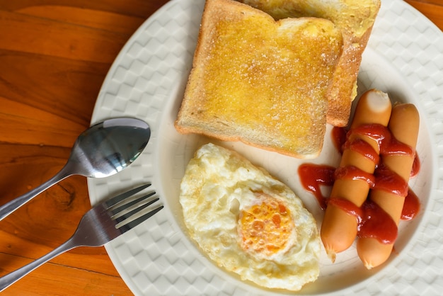 Colazione, uova, pane e hot dog sul pavimento di legno.