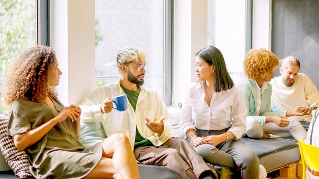 Collaboratori che chiacchierano rilassati durante la pausa caffè seduti sulle sedie