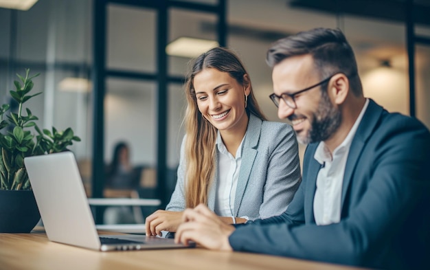 Collaborazione aziendale Colleghi sorridenti che usano il portatile in ufficio